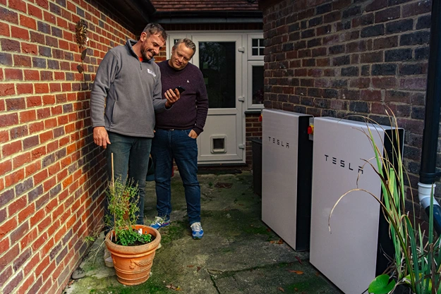 Helios Energy team installing a Tesla Powerwall in a clients home.